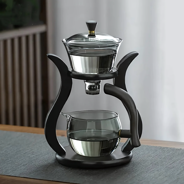 Théière en verre Asuka avec support noir moderne et poignées ergonomiques, parfaite pour infusions de qualité.