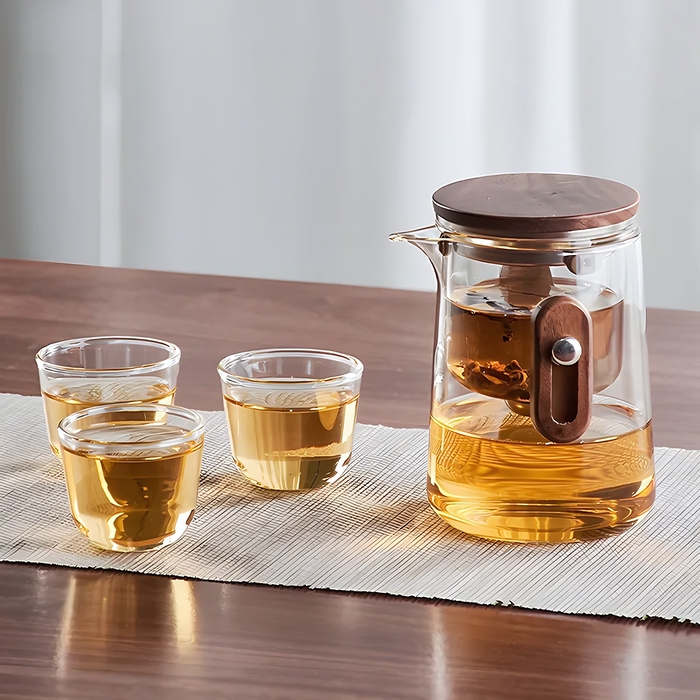 Théière Kaji portable en verre transparent avec infuseur, tasses assorties et pochette de transport élégante.