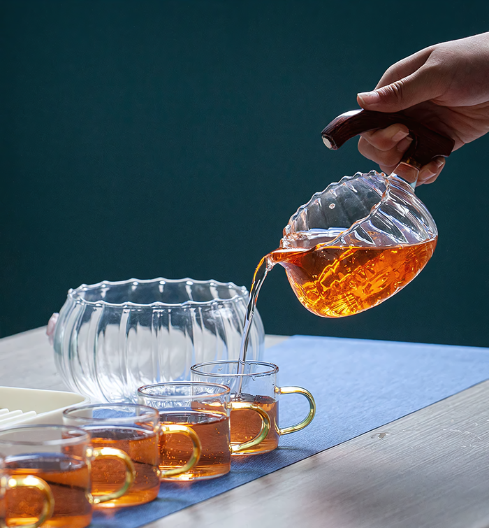 Théière Sora en verre avec base sculptée en bois, design élégant et artistique, parfait pour une expérience de thé raffinée.