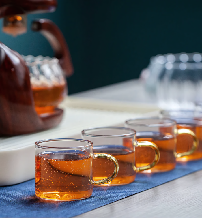 Théière Sora en verre avec base sculptée en bois, design élégant et artistique, parfait pour une expérience de thé raffinée.