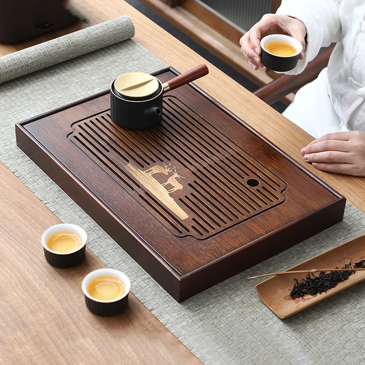 Plateau à thé en bois élégant, avec théière et tasses assorties, parfait pour une cérémonie du thé raffinée.